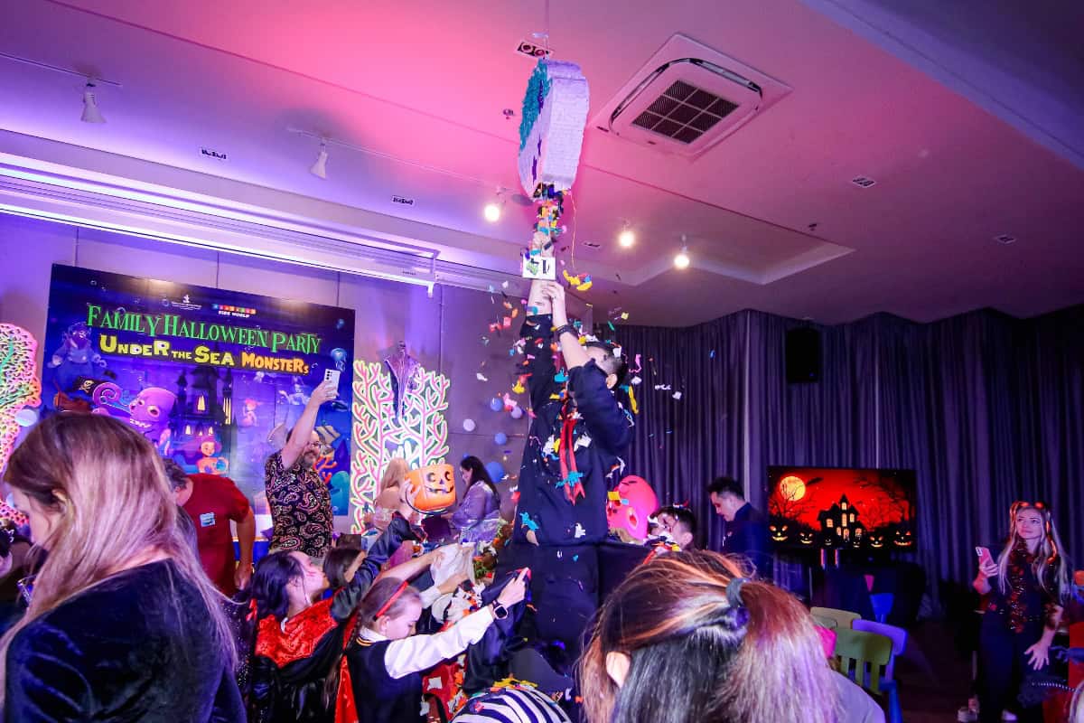 children busting open a pinata for candy at halloween party